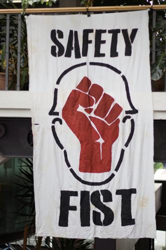 A banner in portrait orientation, containing a stylized red fist an the slogan "Safety Fist"